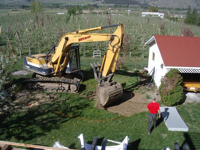 Excavator breaking ground for a new pool